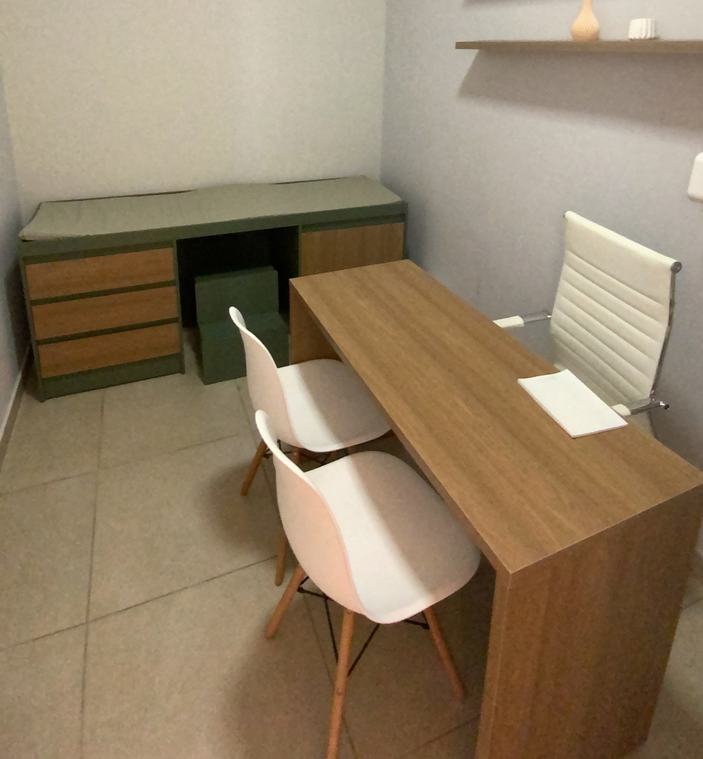 Sala de atendimento com maca e mesa