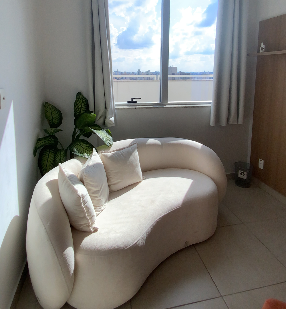 Espaço de espera com sofá e vista para a cidade